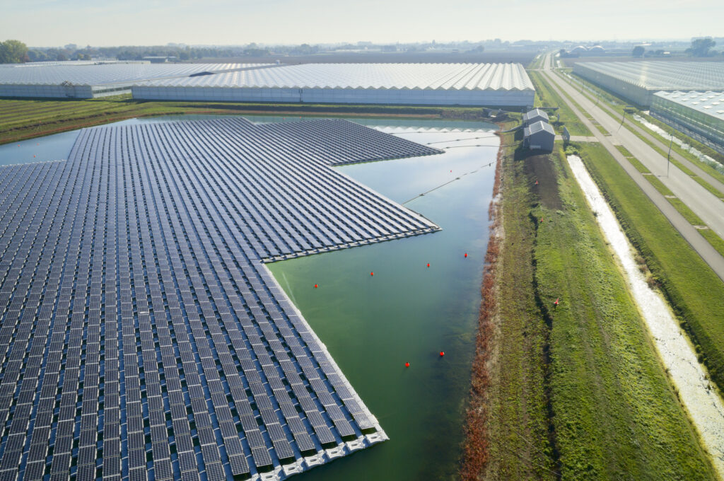 Floating solar panels installed on water supply of neighbouring greenhouses, elevated view, Netherlands. Image: Mischa Keijser / Getty