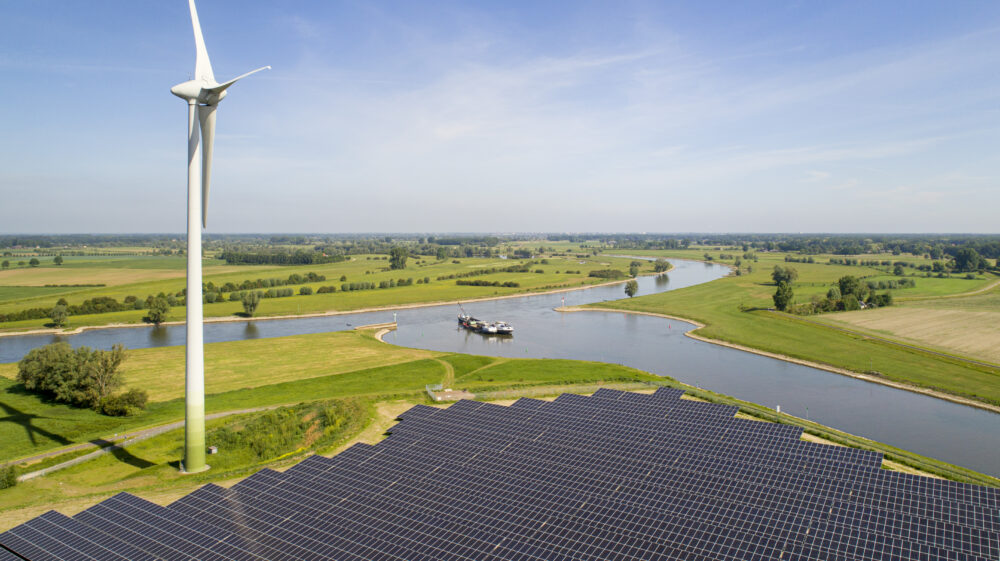 Solar panels and wind turbine near Ijssel river, The Netherlands. Image: Mischa Keijser / Getty