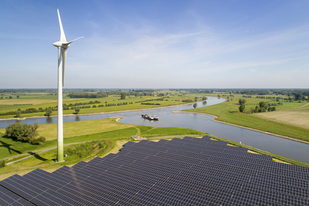 Solar panels and wind turbine near Ijssel river, The Netherlands. Image: Mischa Keijser / Getty