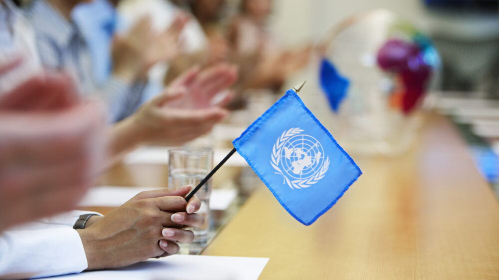 Businesswoman holding UN flag in meeting