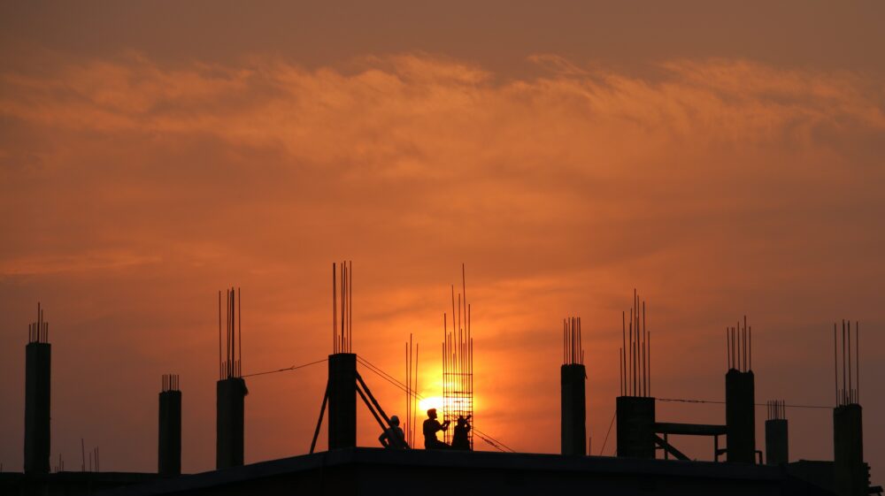 Silhouette of men at construction site during sunset