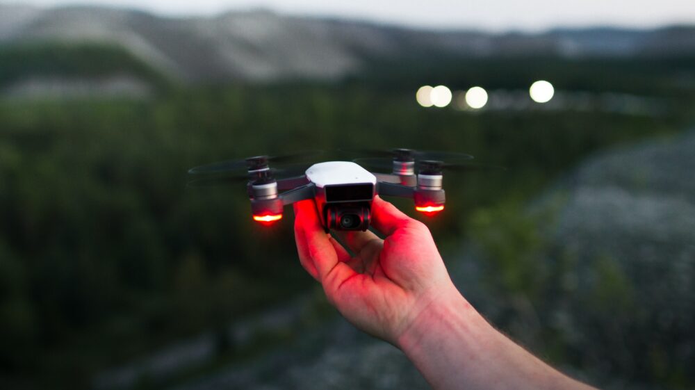 Person holding black and red quadcopter