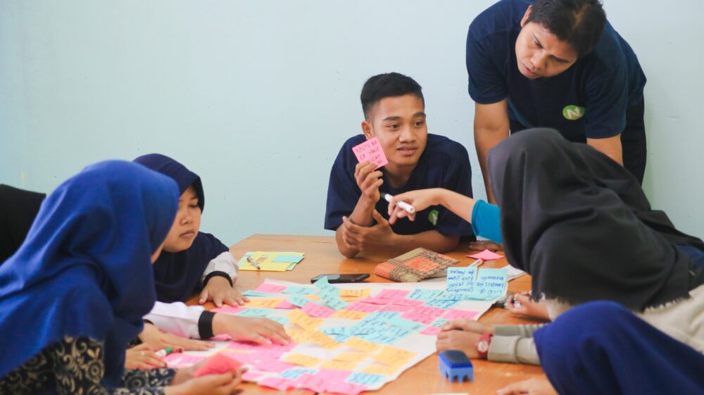 Indonesian students brainstorming with Post-It notes