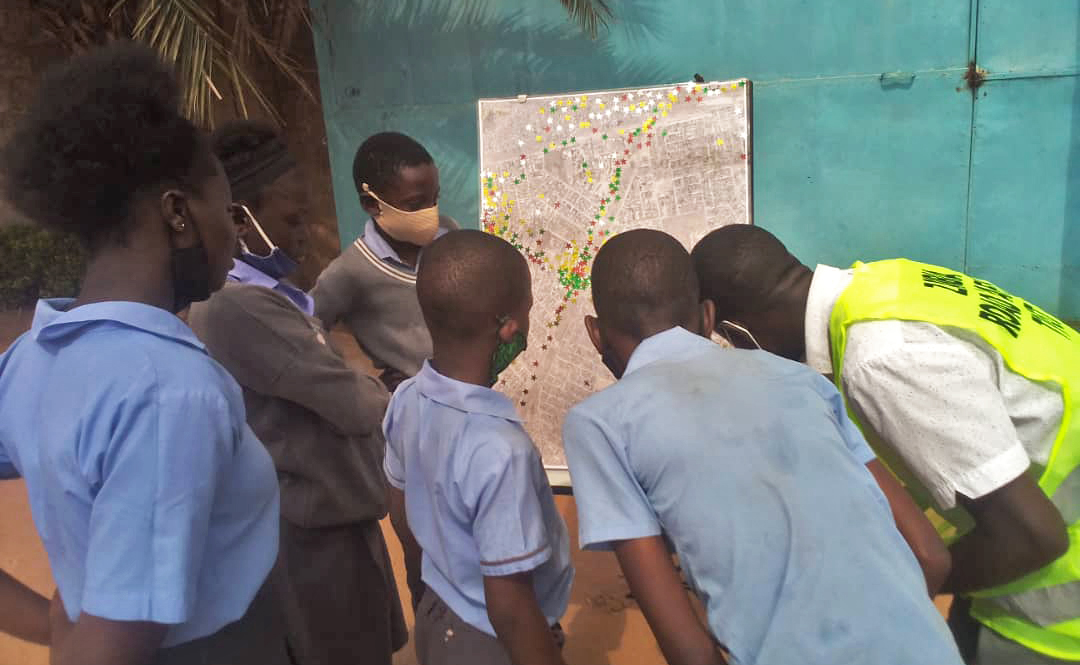 Schoolchildren in Lusaka, Zambia looking at a map of transport hotspots