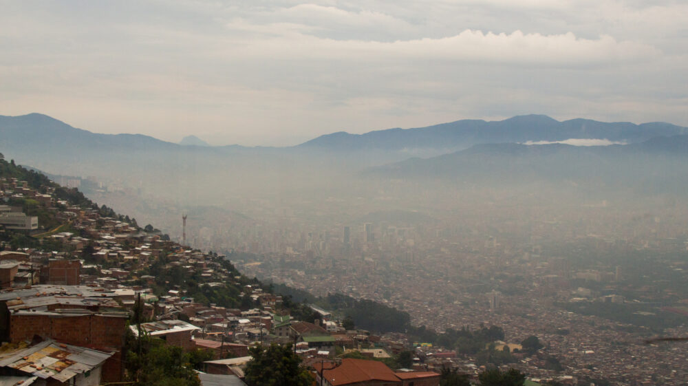 View over Medellín, Colombia, located in a valley between mountains, smog over downtown area