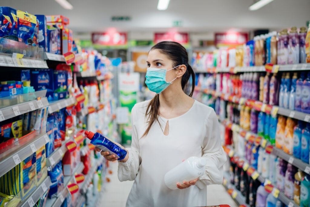 Woman wearing face mask shopping for household cleaning products