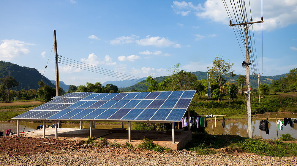 Solar panels under blue sky in rural backyard, Luang Prabang, Laos