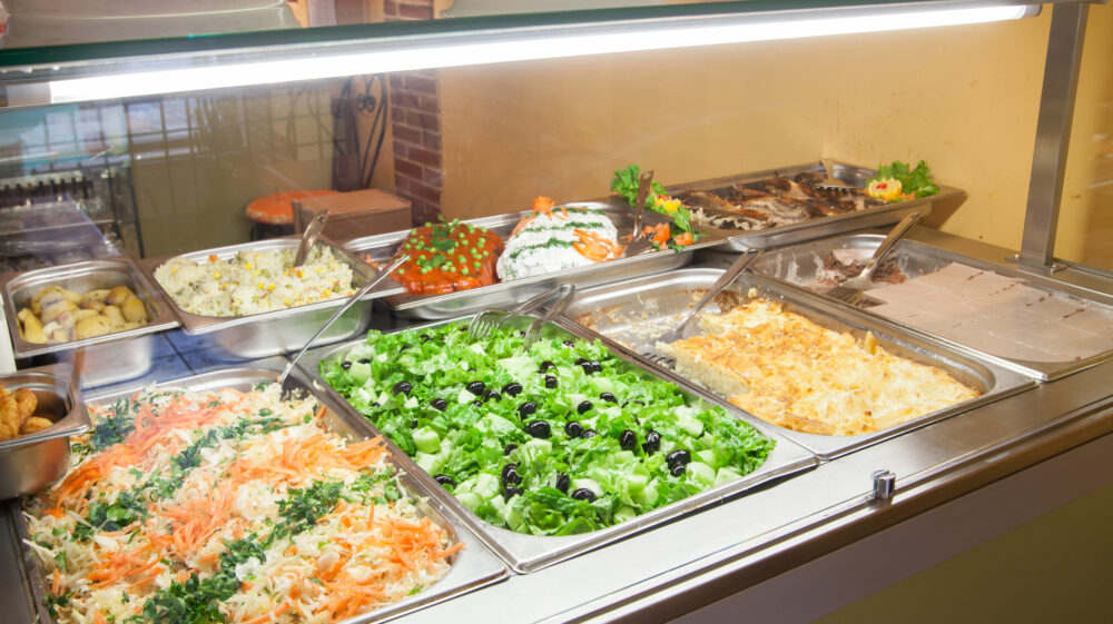 Shredded and gree salads, rice and desserts as takeout food in showcase window