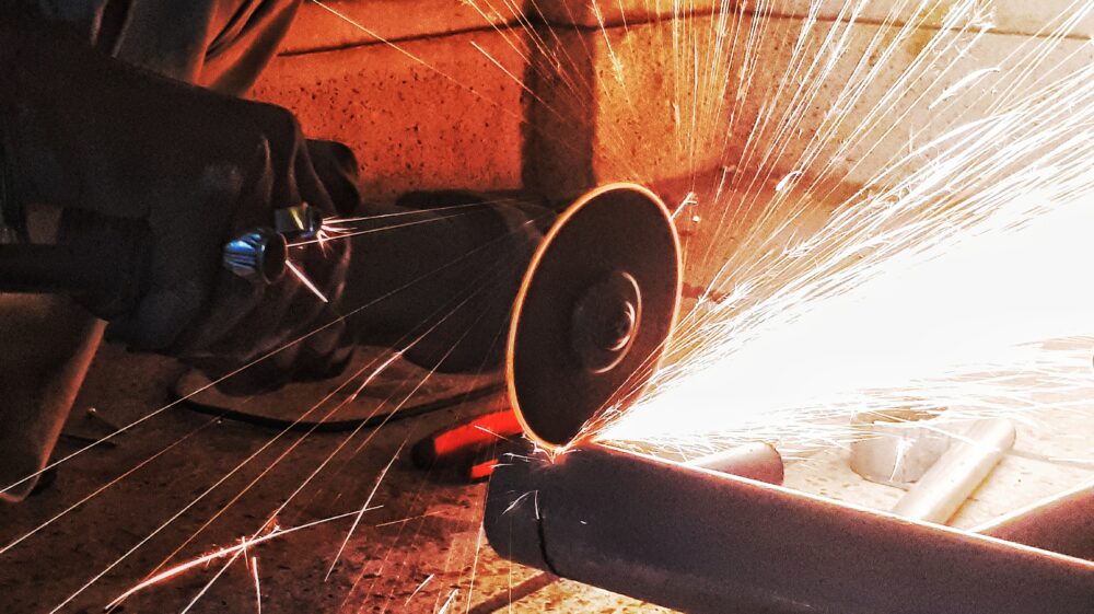 Circular saw cutting through steel pipe, Hyderabad, Pakistan, 2018