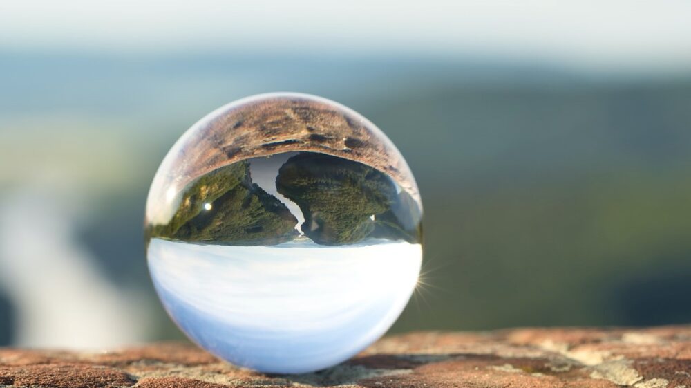 Transparent globe reflecting sky and earth