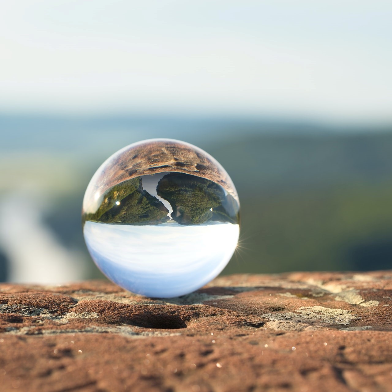 Transparent globe reflecting sky and earth