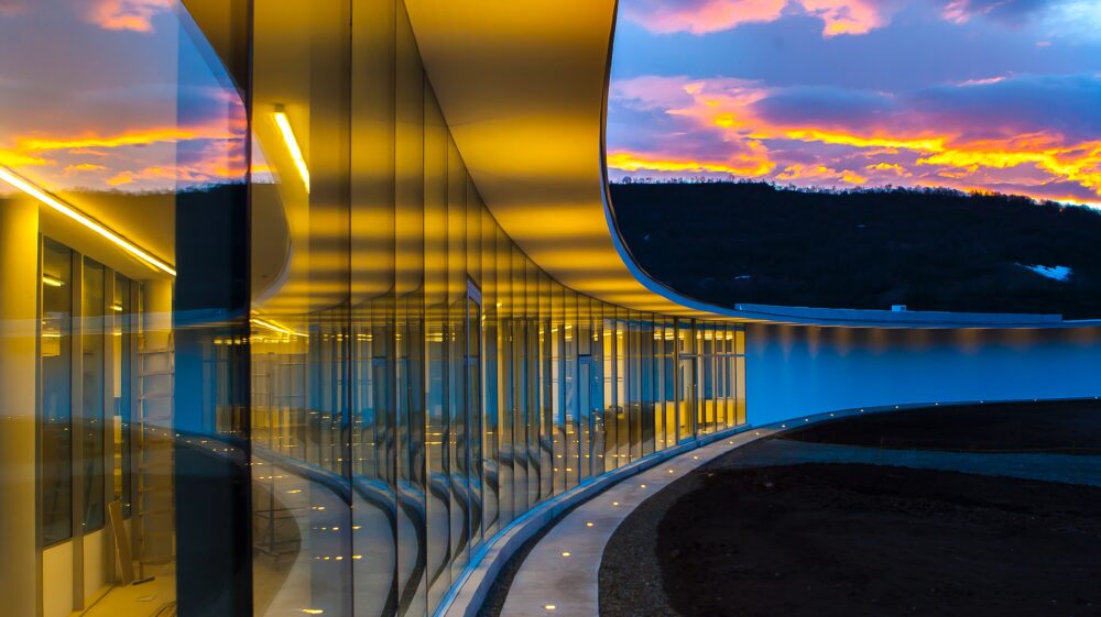 COAF Smart Center, a clear glass wall building under blue and orange sky with clouds, Lori, Armenia, March 2019