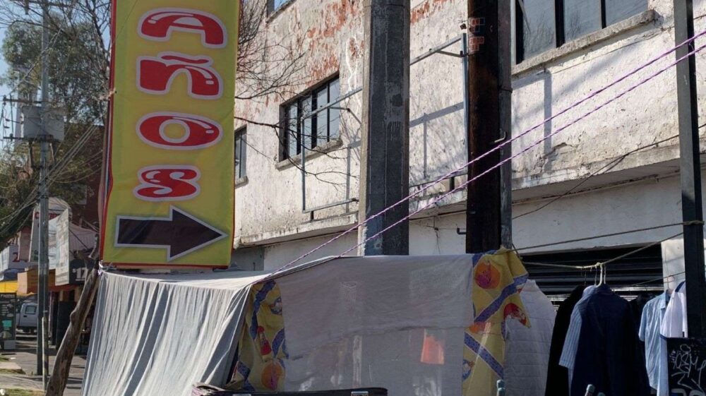 Large yellow sign indicating where toilets are located outside a building in Mexico City