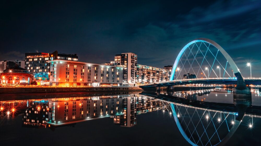 Glasgow on the River Clyde at night with lit buildings and bridge