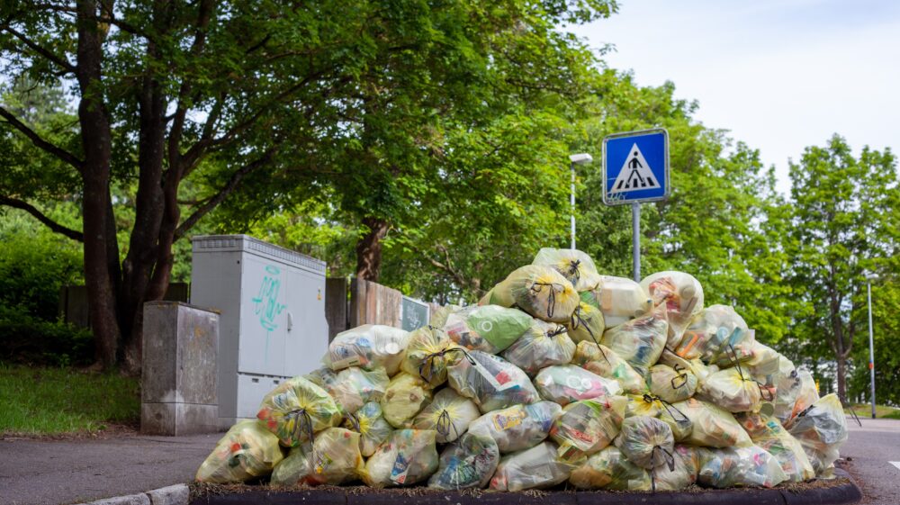 Pile of trash in transparent yellow bags on street, Tübingen, Germany