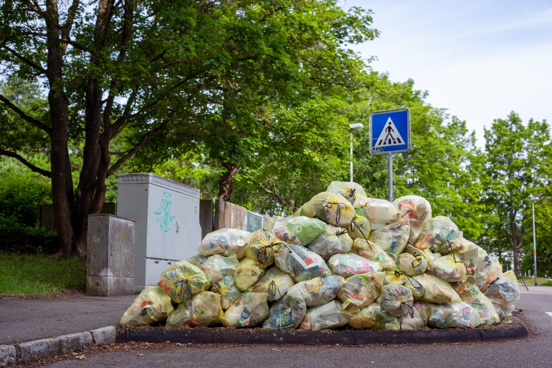 Pile of trash in transparent yellow bags on street, Tübingen, Germany