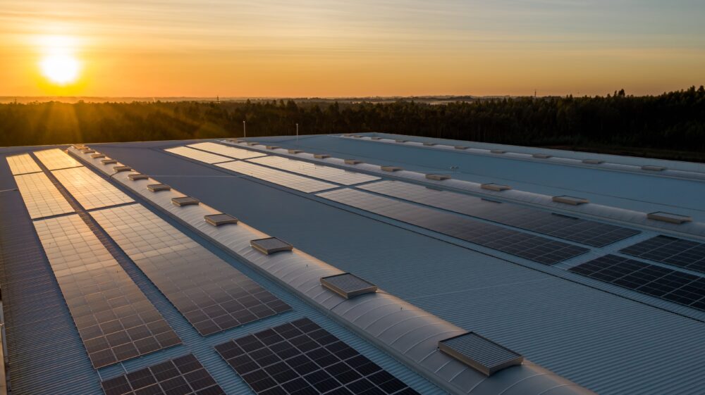Solar panels on roof at sunset with fields in background, February 2021