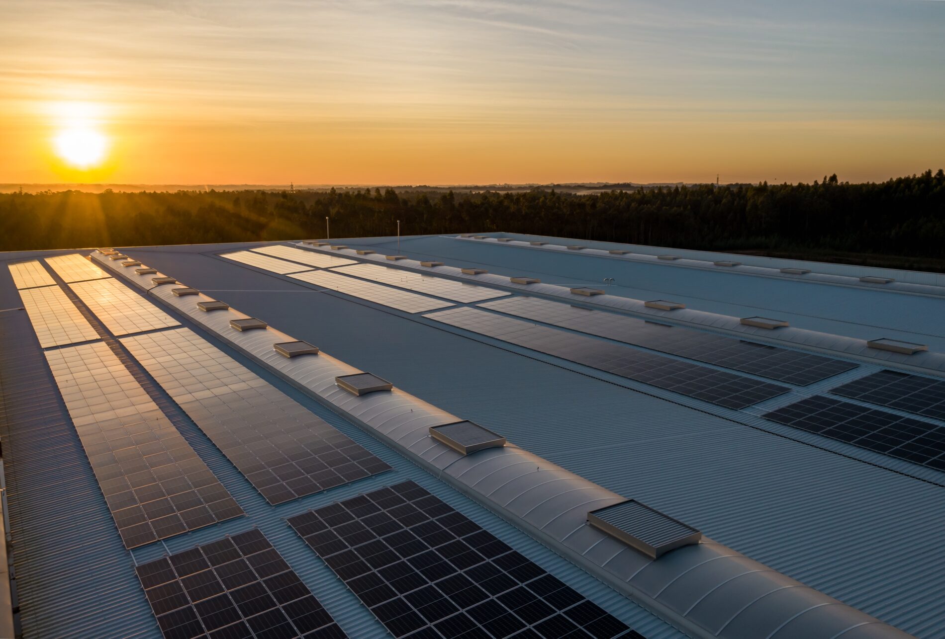 Solar panels on roof at sunset with fields in background, February 2021