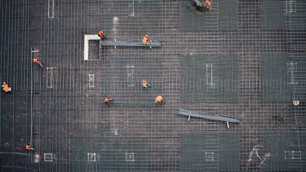 Aerial photo of construction workers laying steel lattice rods on worksite taken from higher building, Sulaymaniyah, Kurdistan Region, Iraq, 2018
