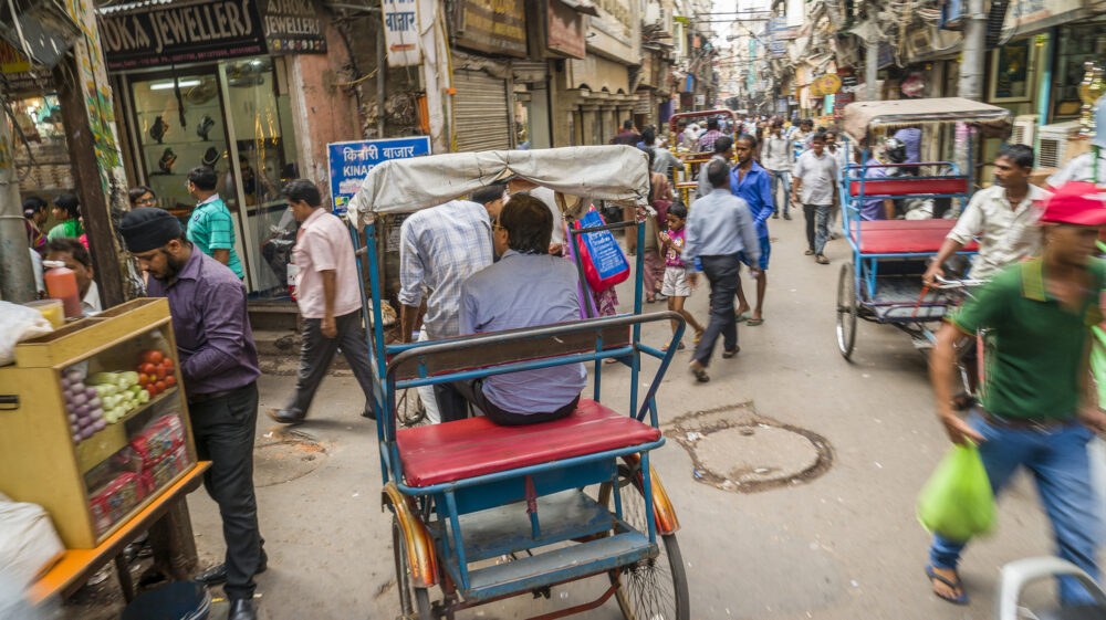 Crowded lane with rickshaws around Jama Masjid Mosque, Delhi, India