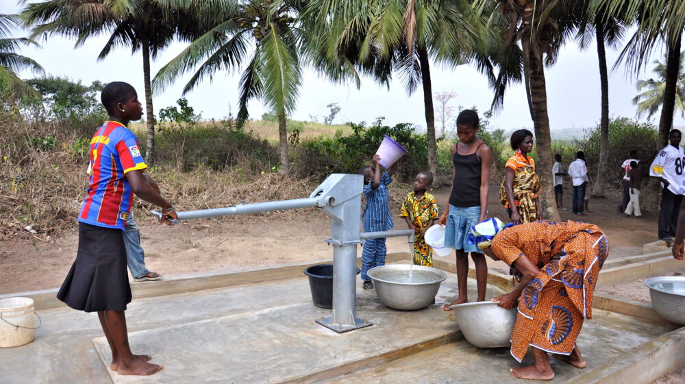 Women pump and collect water at a water pump provided by USAID, Ghana, 2012