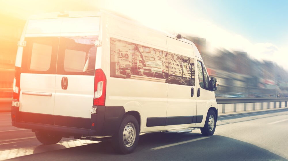 White van driving in passing lane on blurred street