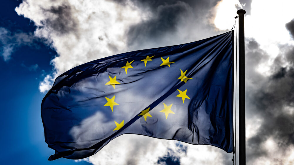 EU flag under cloudy blue sky, Berlin, Germany