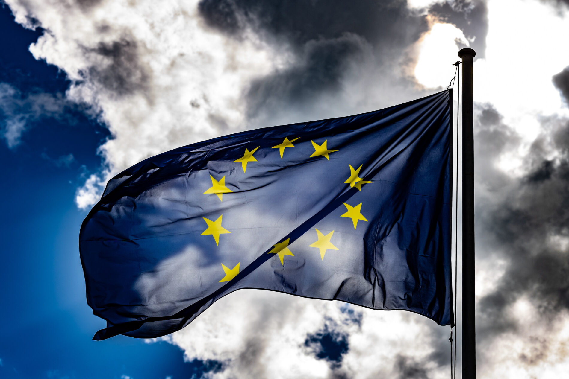 EU flag under cloudy blue sky, Berlin, Germany