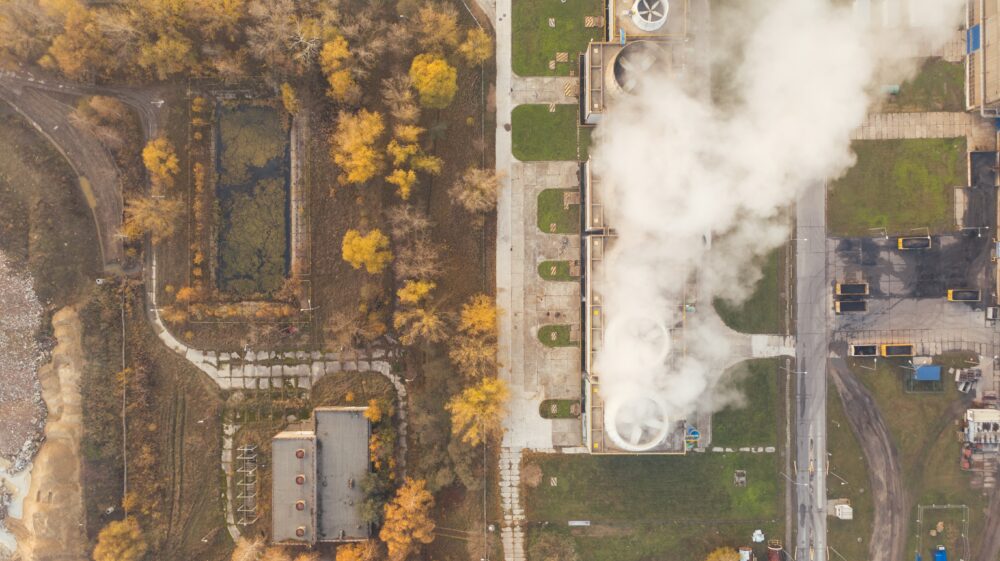Aerial view of industrial chimneys with billowing smoke