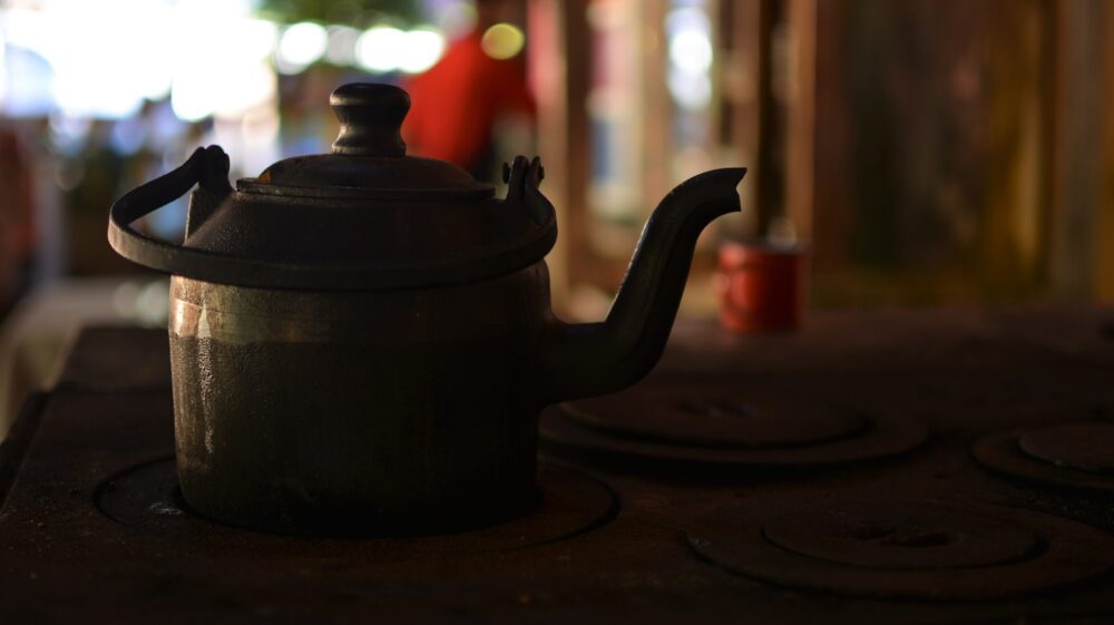 Kettle sits atop a wood-burning stove