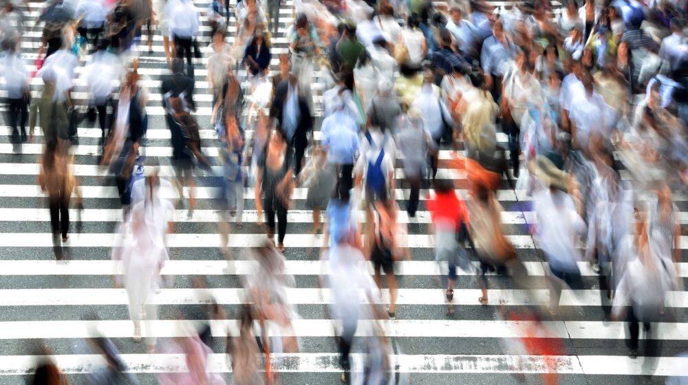 Blurred pedestrians at busy city crosswalk
