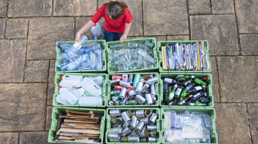 Teenage girl organizing recycling bins