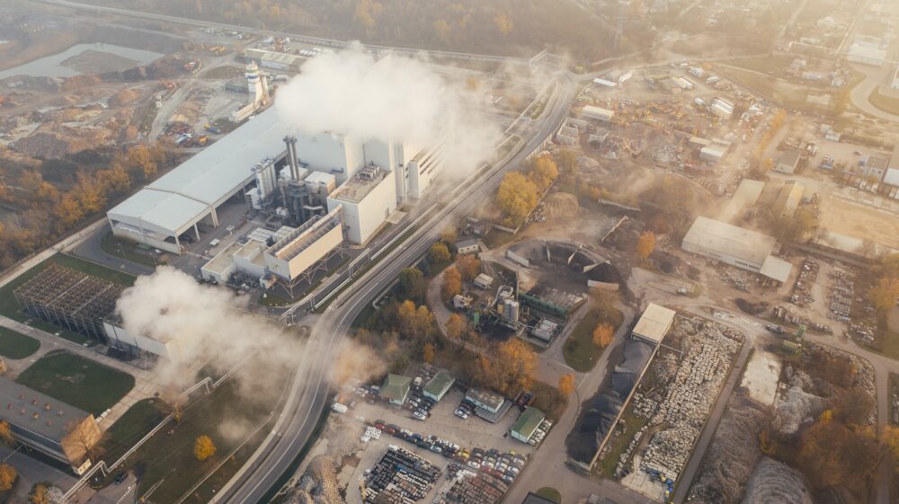 Aerial view of white smoke billowing over factory in autumn, Poznań, Poland