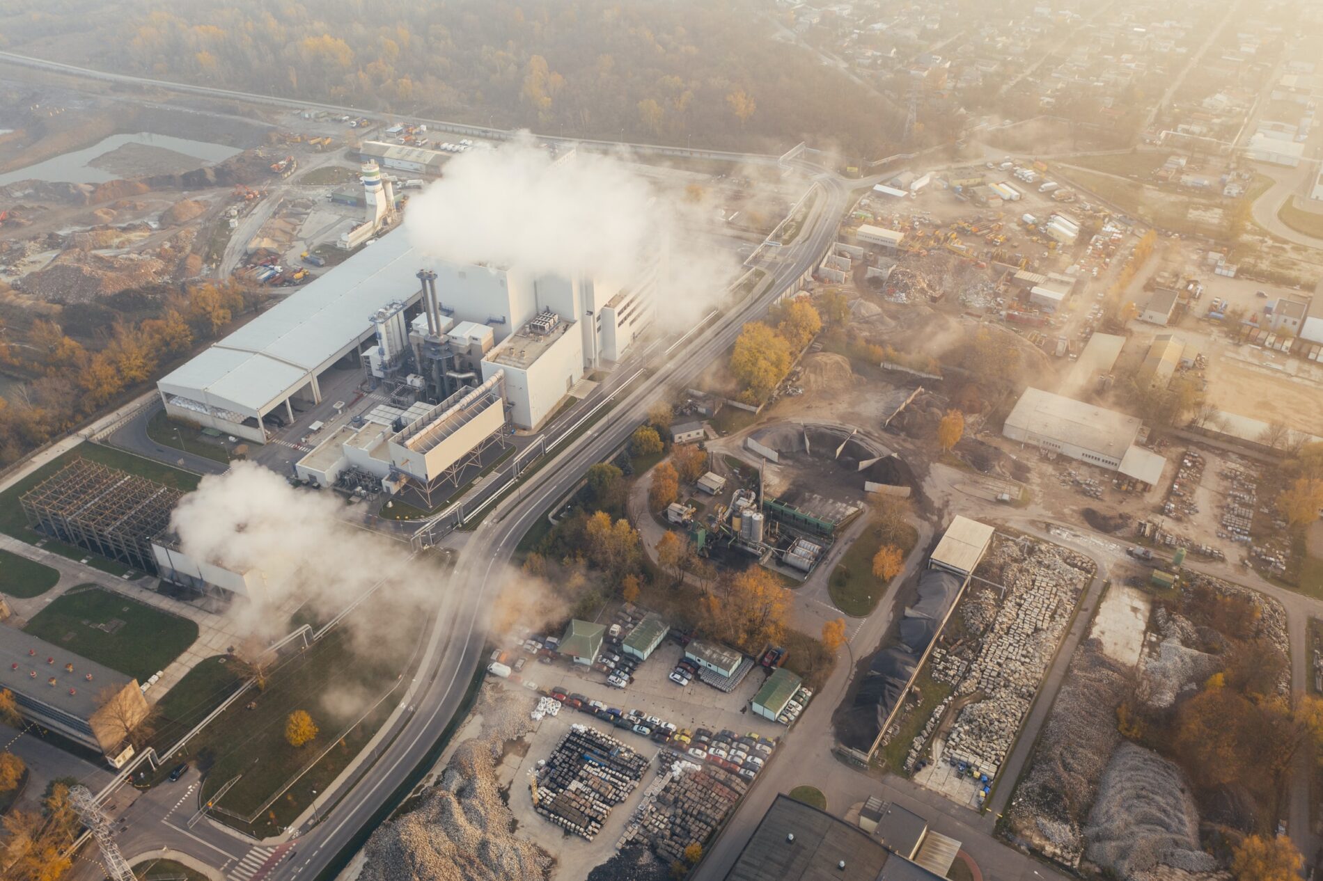 Aerial view of white smoke billowing over factory in autumn, Poznań, Poland