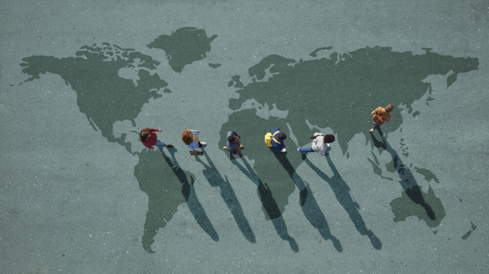 Young people walking in a line on a map of the world in dark green, Cape Town, Western Cape, South Africa