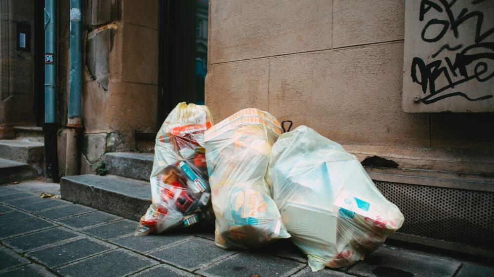 3 full plastic garbage bags on sidewalk, Fürth, Germany