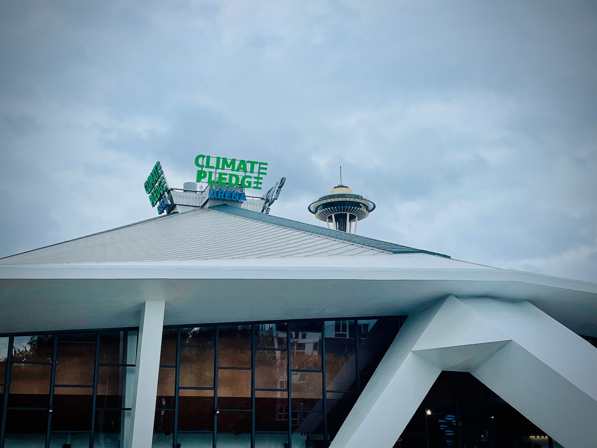 Climate Pledge Arena in front of Space Needle under grey Seattle sky
