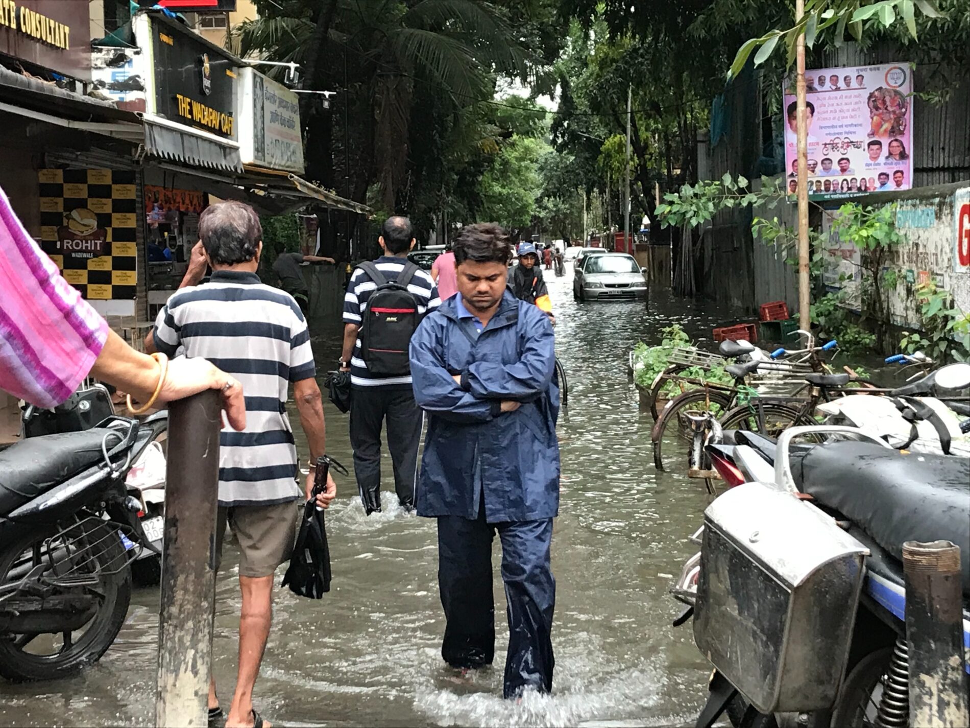 Residents walking down flooded street, Mumbai, India