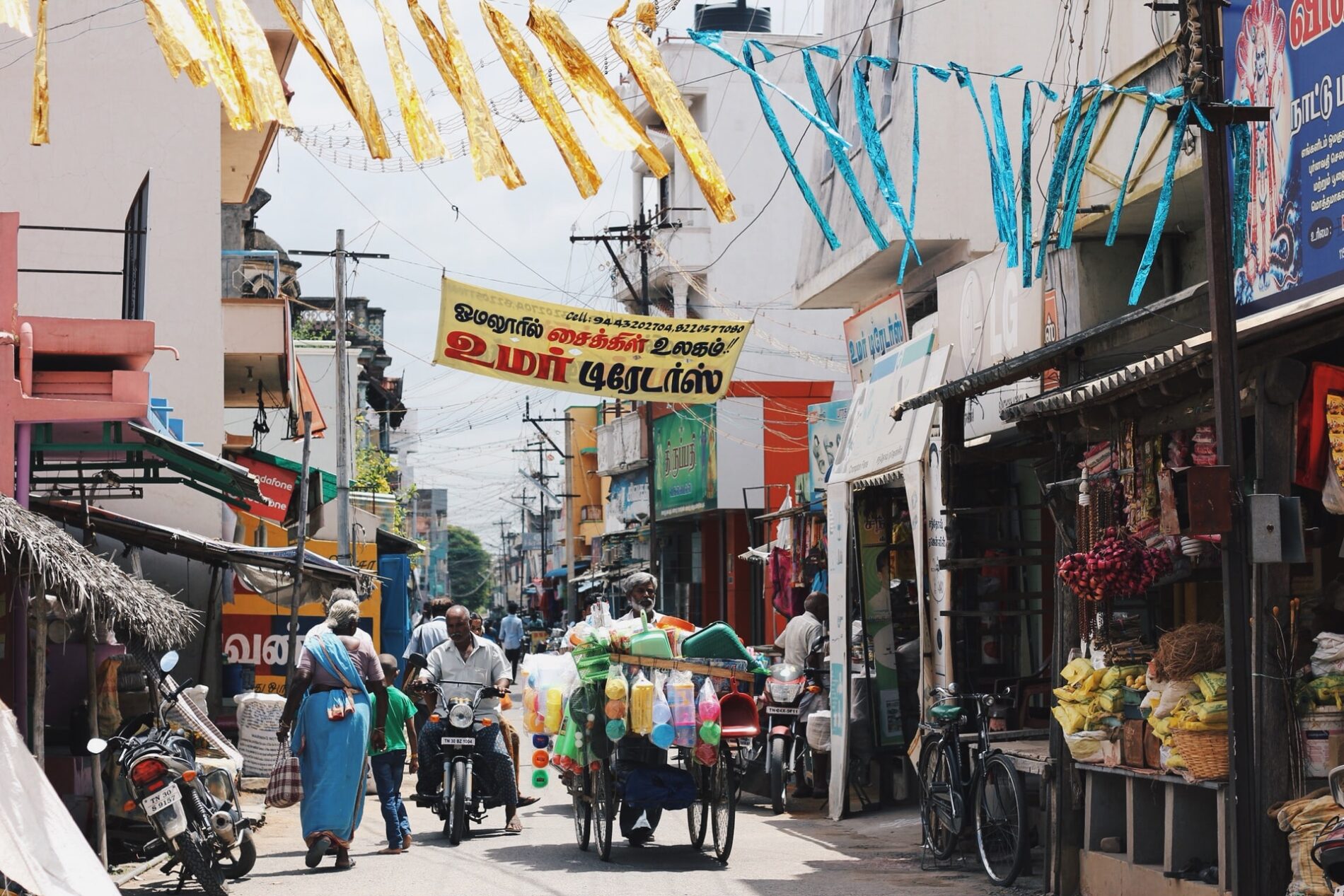 Lane with shops, pedestrians and motorbikes in southern India