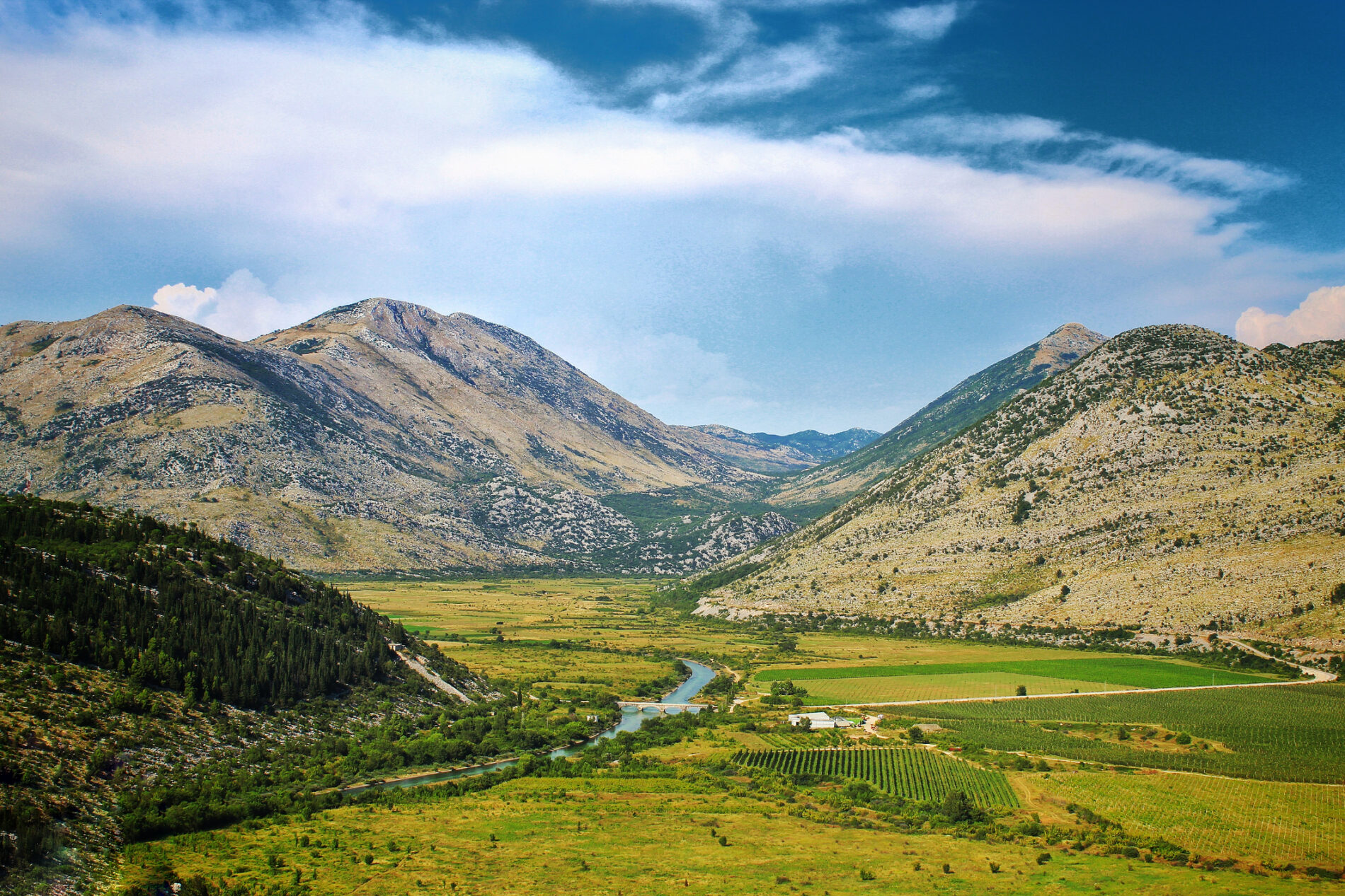 Green field valley with surrounding hills taken in Trebinje, Bosnia and Herzegovina