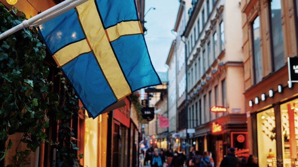 A shopping street in Sweden with Swedish flag in the foreground