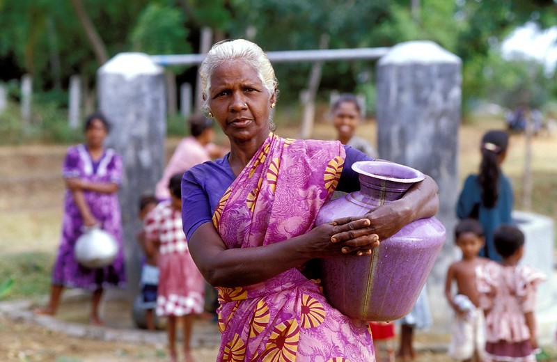 Woman collecting water from a well