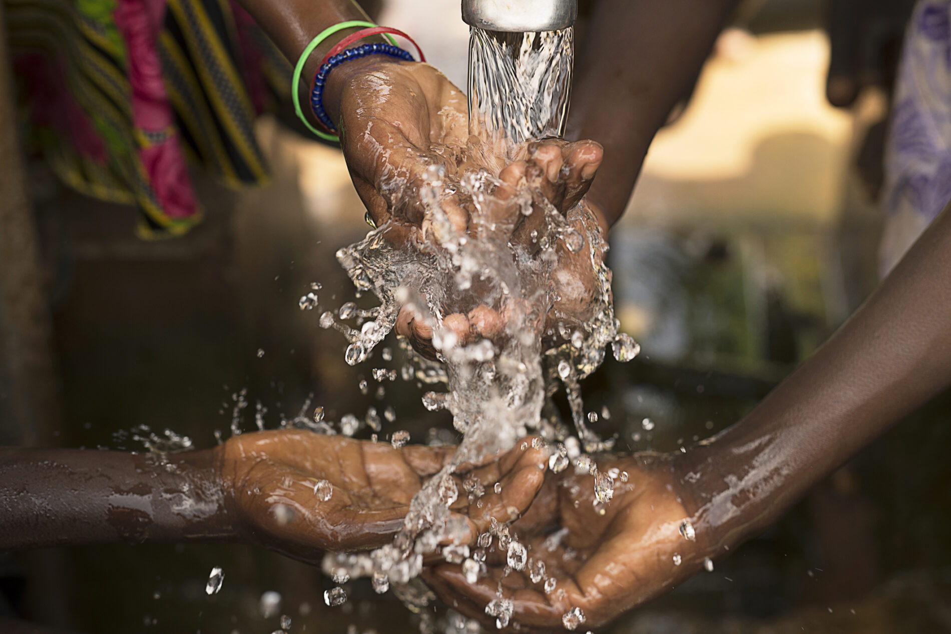 Stream of water pouring into children’s hands in southern Burkina Faso. Photo: Jadwiga Figula / Getty
