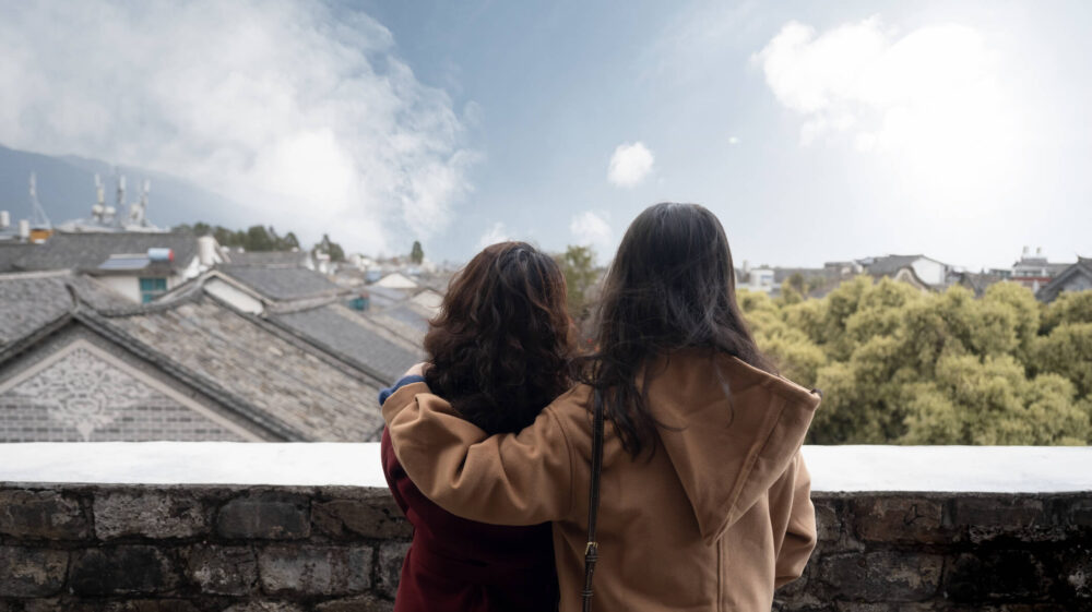 Two people looking over a cloudy skyline