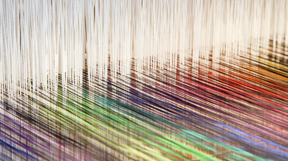 Colourful threads on an old-fashioned loom