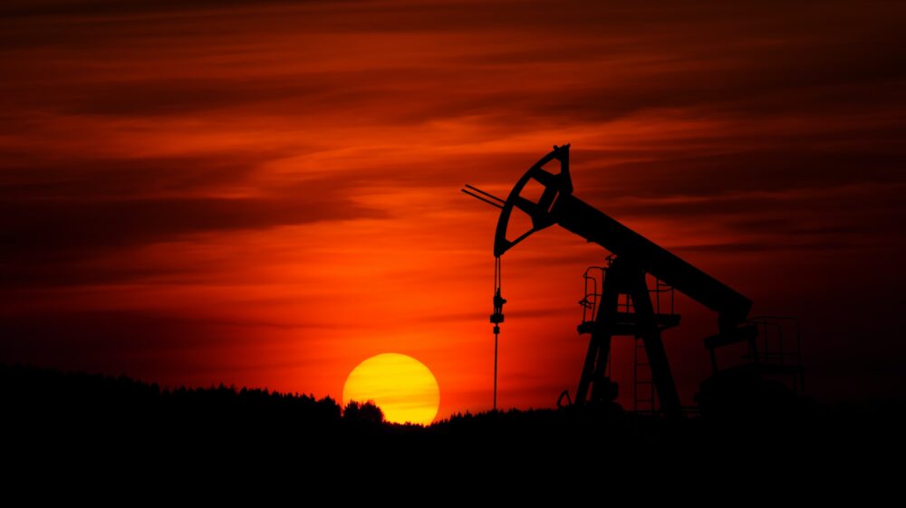 Pumpjack mining crude oil at sunset
