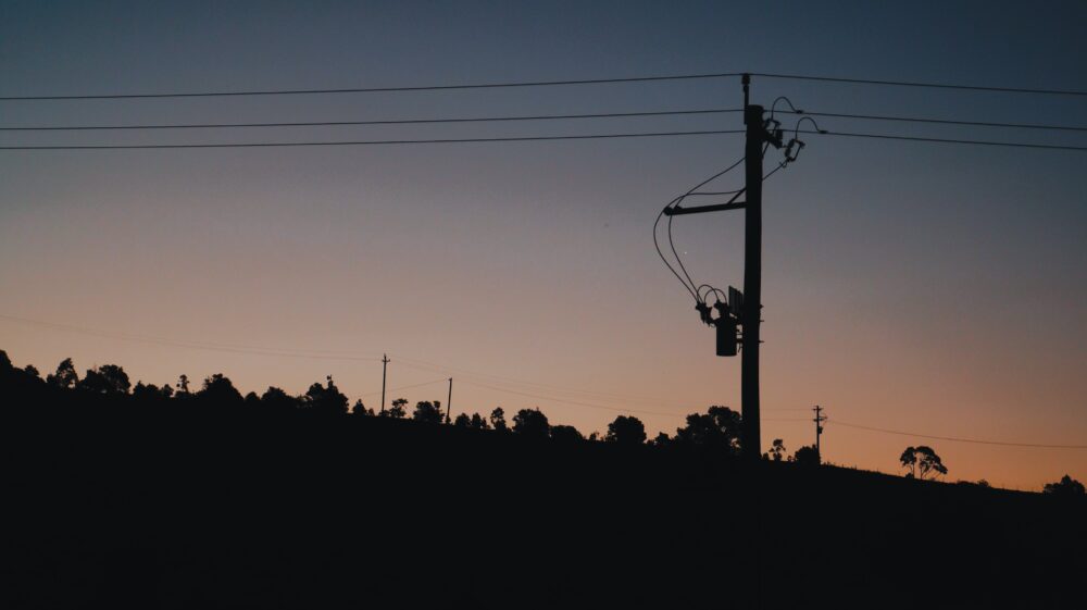 The skyline at dusk: a telegraph pole in front of the vibrant ombre of the sky.