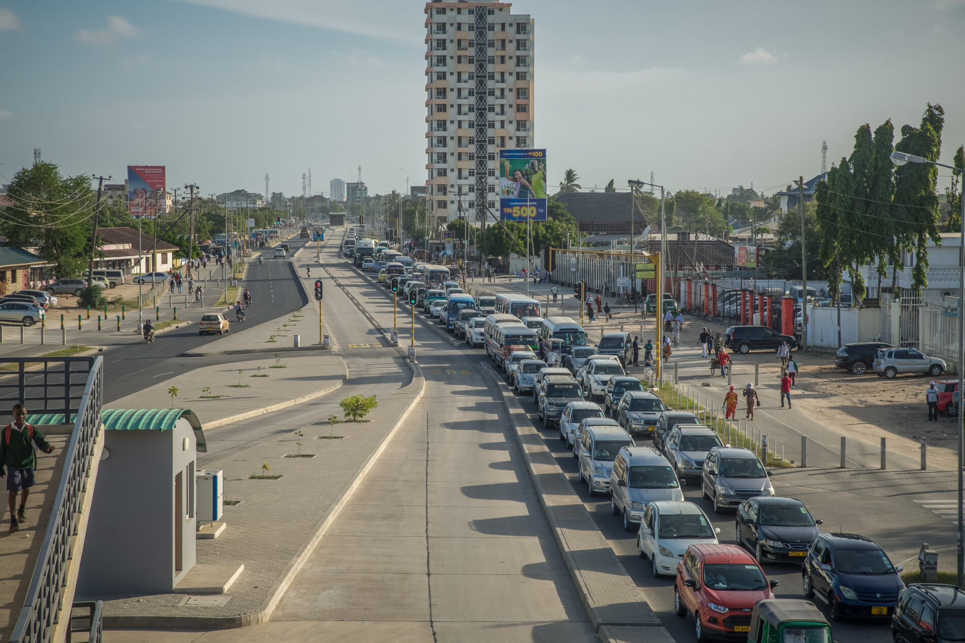 Trafic congestion on a major road in the city of Dar Es Salaam, and a new bus lane and bus stop, investment in the transport infrastructure