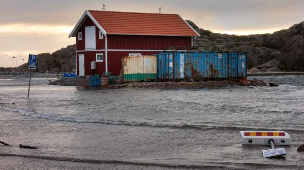 Red building surrounded by water at a beach in Lysekil during Storm Ciara © W.CARTER / WIKIMEDIA