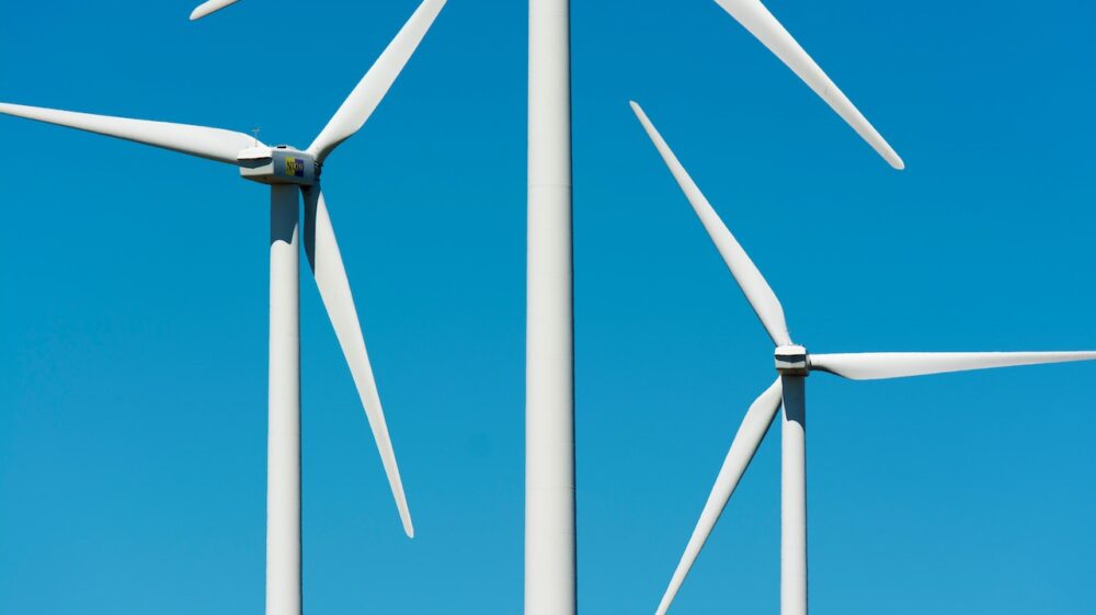 White Wind Turbines Under the Clear Blue Sky